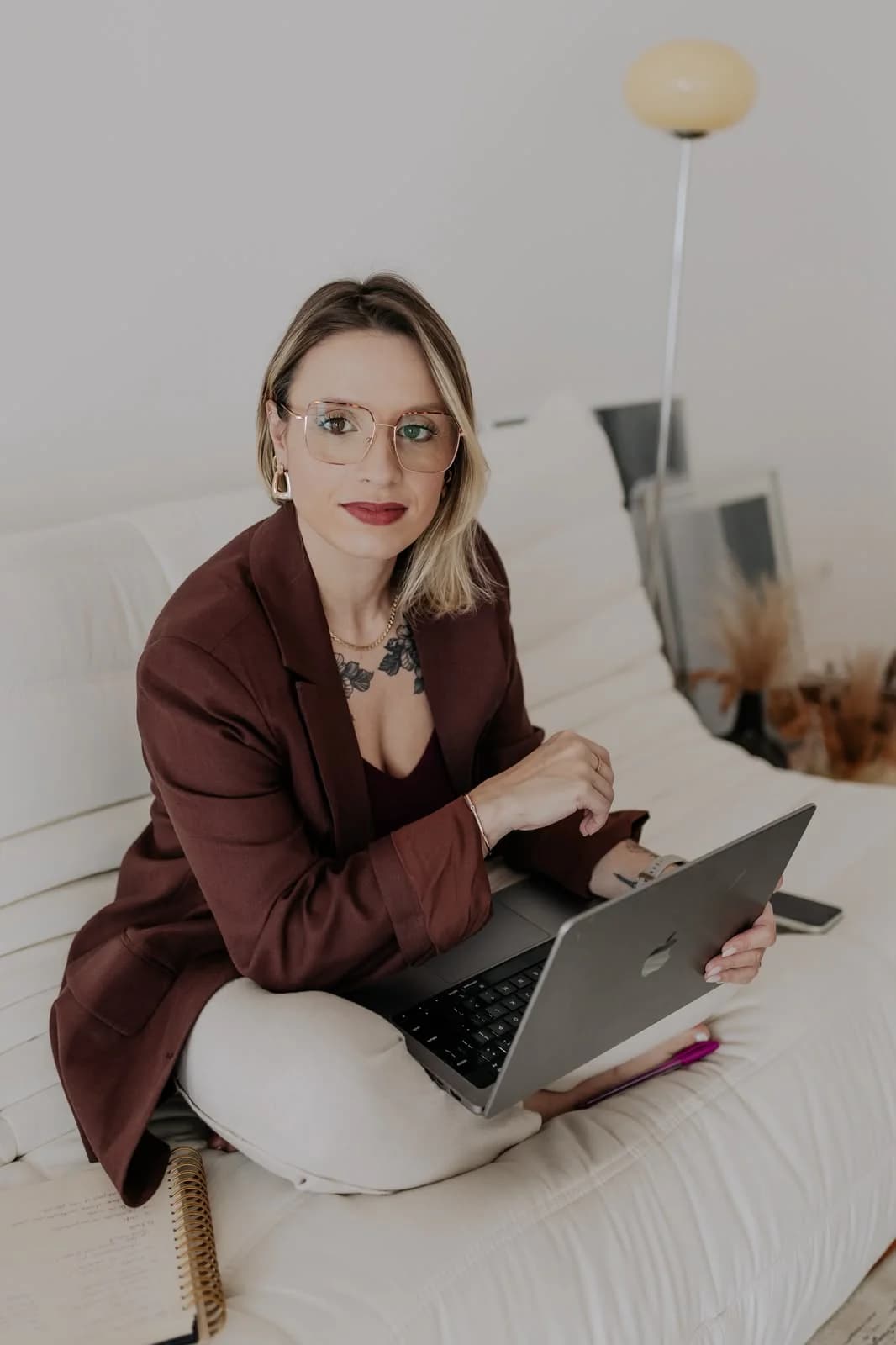 Nathaly Rodrigues trabalhando no notebook, sentada em um sofá